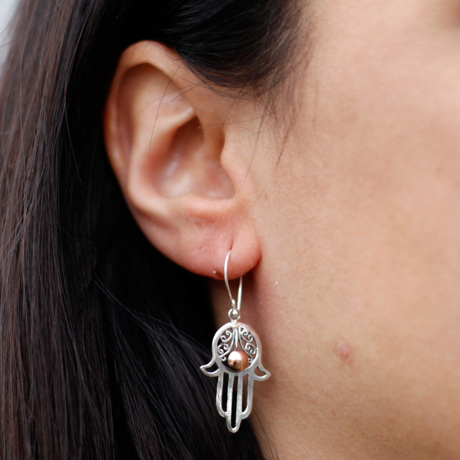 Intricate mixed metal Hamsa hand drop earrings featuring both silver and gold finishes.