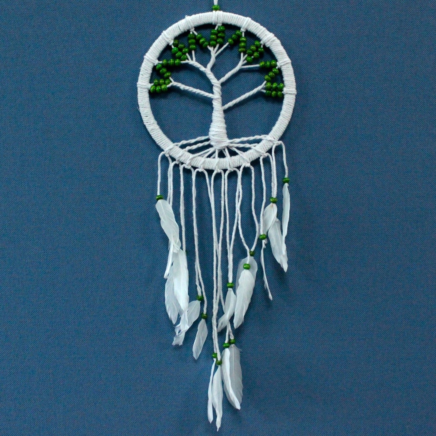 Intricate white macrame dreamcatcher featuring a central Tree of Life design and long flowing cotton tassels.