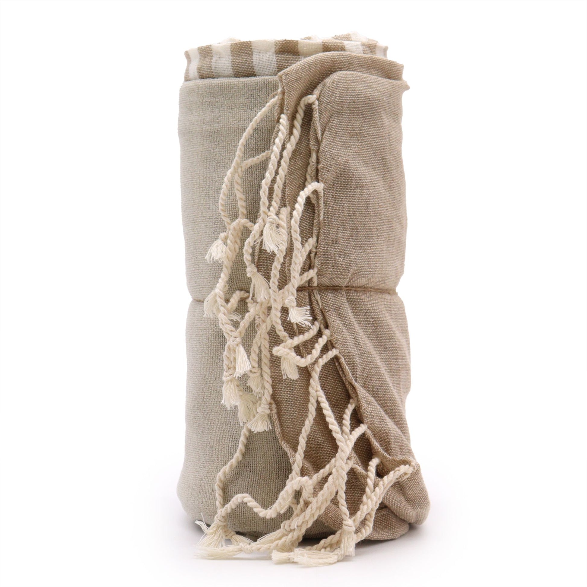 Large cotton pareo towel in a warm sand beige colour with a soft woven texture and fringed edges.