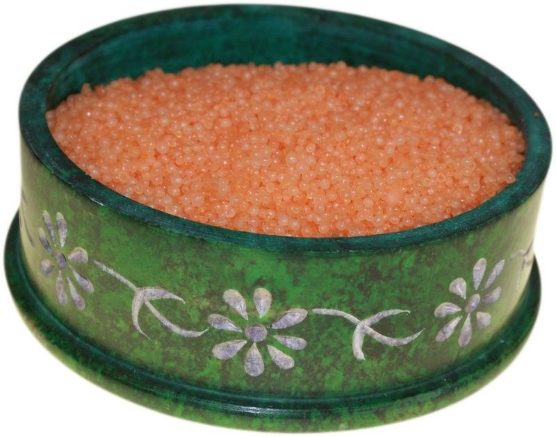Golden shimmering granules for oil burners scattered on a neutral surface.