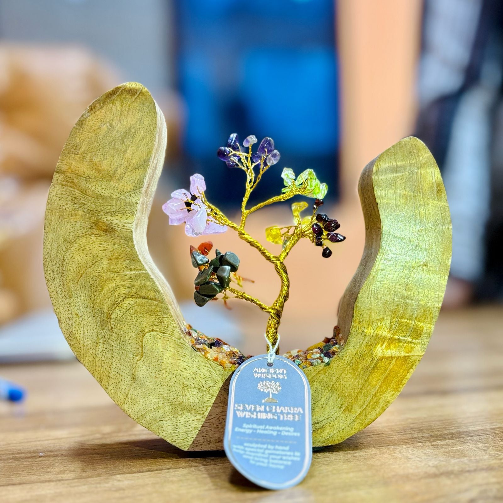 Handcrafted gemstone tree with multicoloured chakra stones set inside a circular mango wood frame.