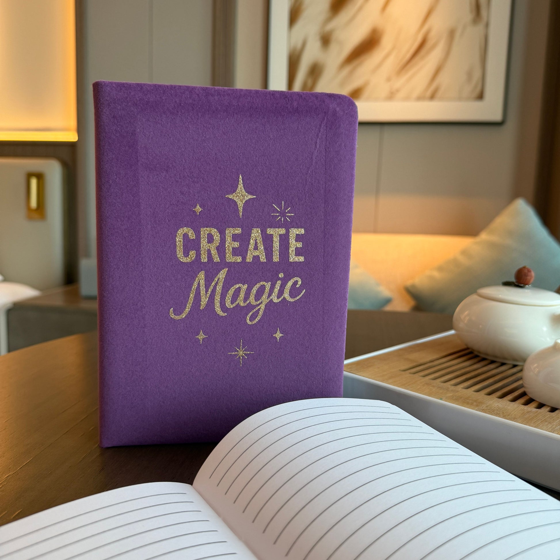 Luxurious purple velvet notebook with gold embossed Create Magic design and lined pages.