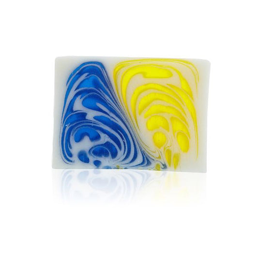 A single slice of artisanal soap with visible botanical textures in soft green and white hues.