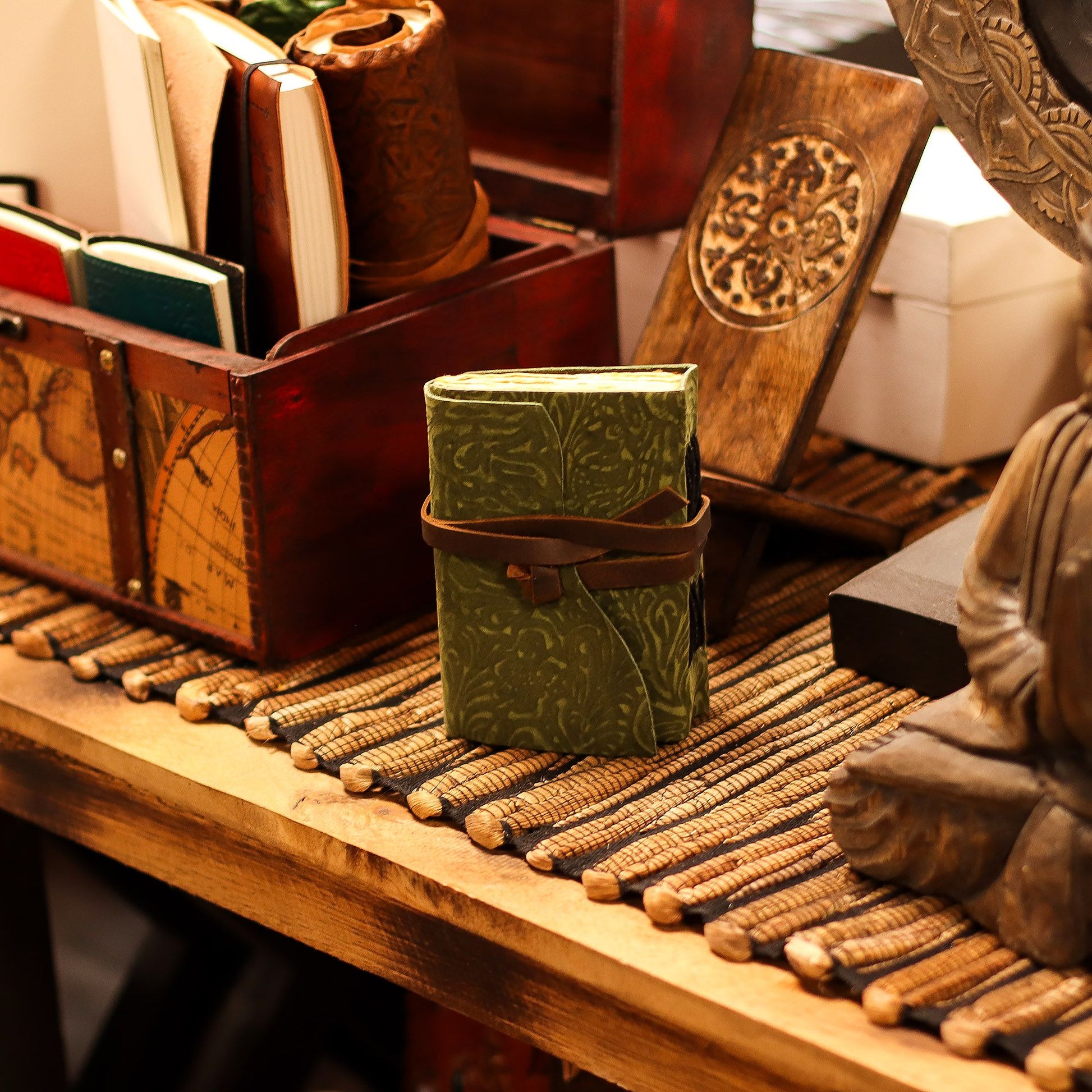 Handmade leather journal with an embossed green maze pattern and rustic deckled edge pages.
