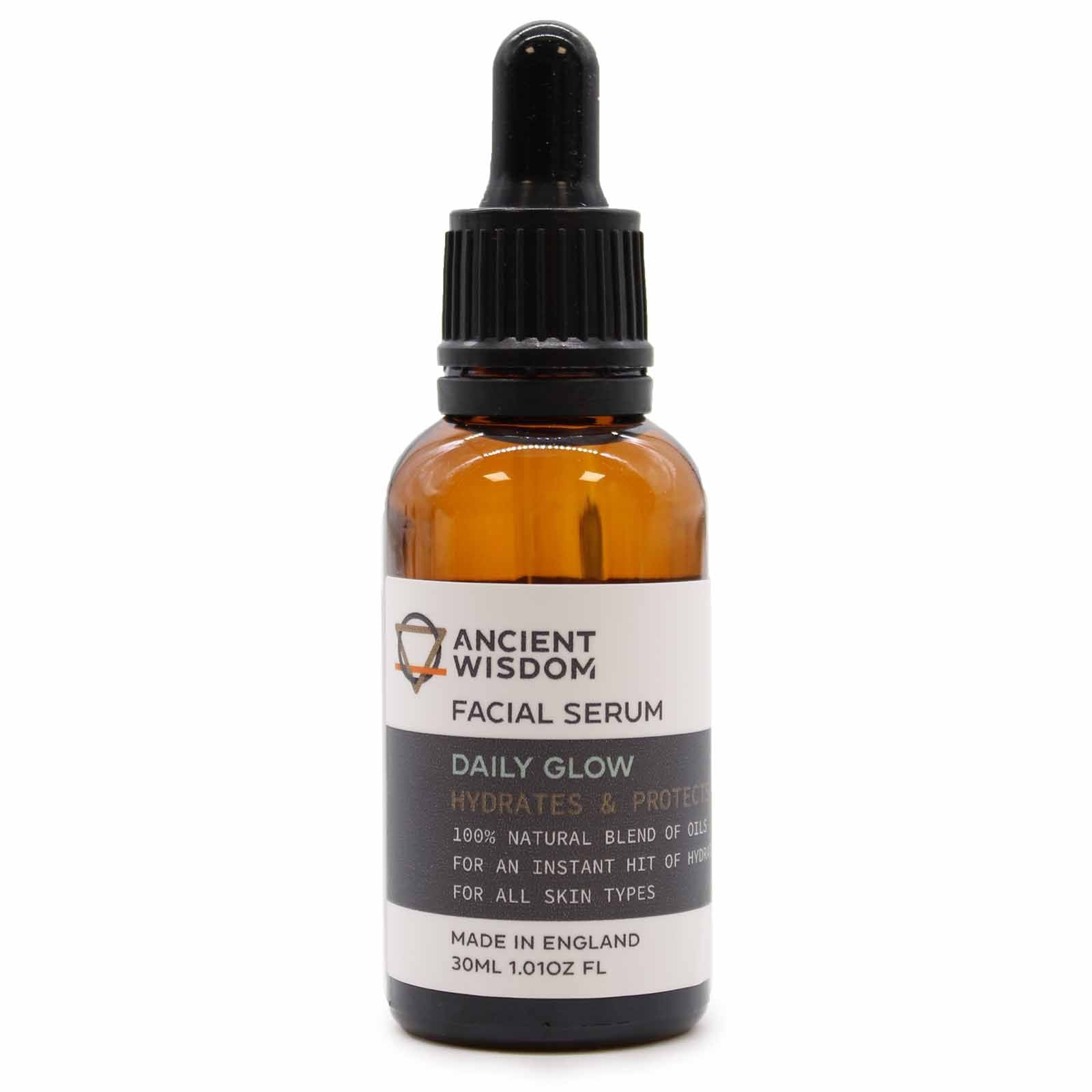 Clear glass bottle of golden facial serum oil with a dropper top on a clean white background.