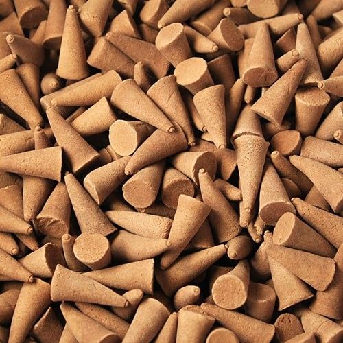 Large batch of aromatic orange and cinnamon incense cones showing a rich textured finish.