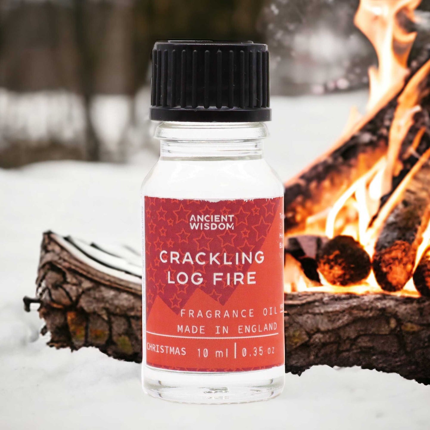 A 10ml amber glass bottle of fragrance oil with a label featuring a warm campfire illustration.