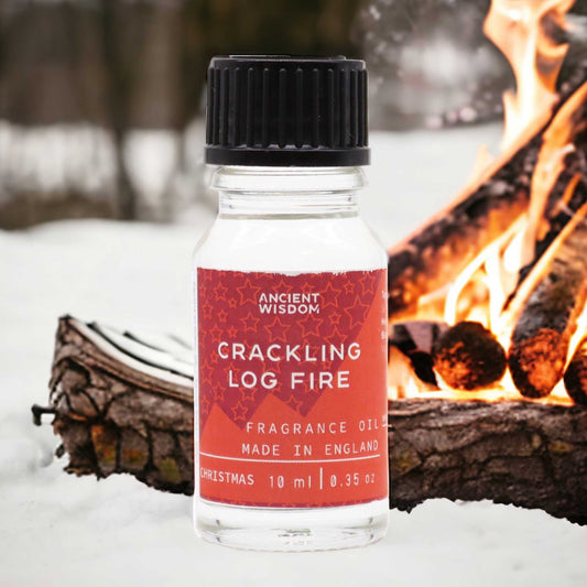A 10ml amber glass bottle of fragrance oil with a label featuring a warm campfire illustration.