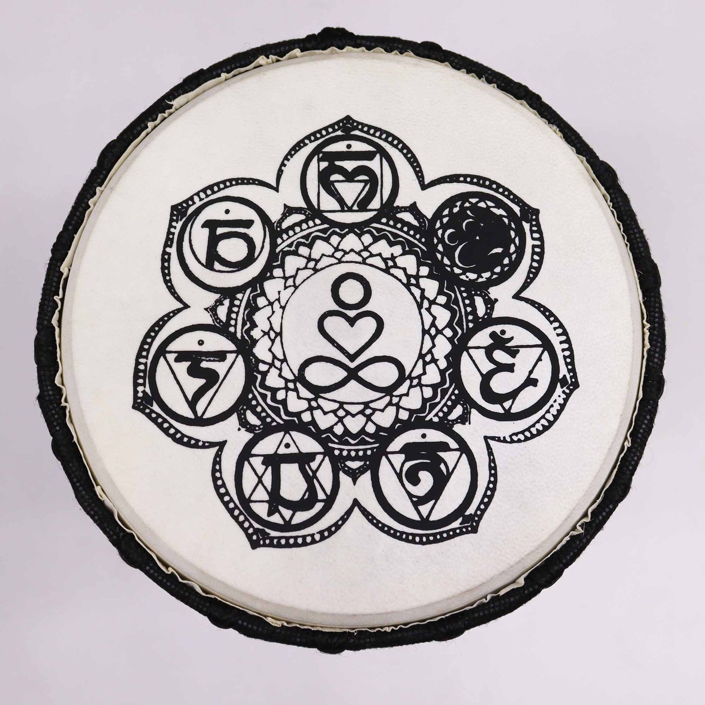Handcrafted wooden djembe drum with a wide top and intricate chakra symbols on the drum skin.