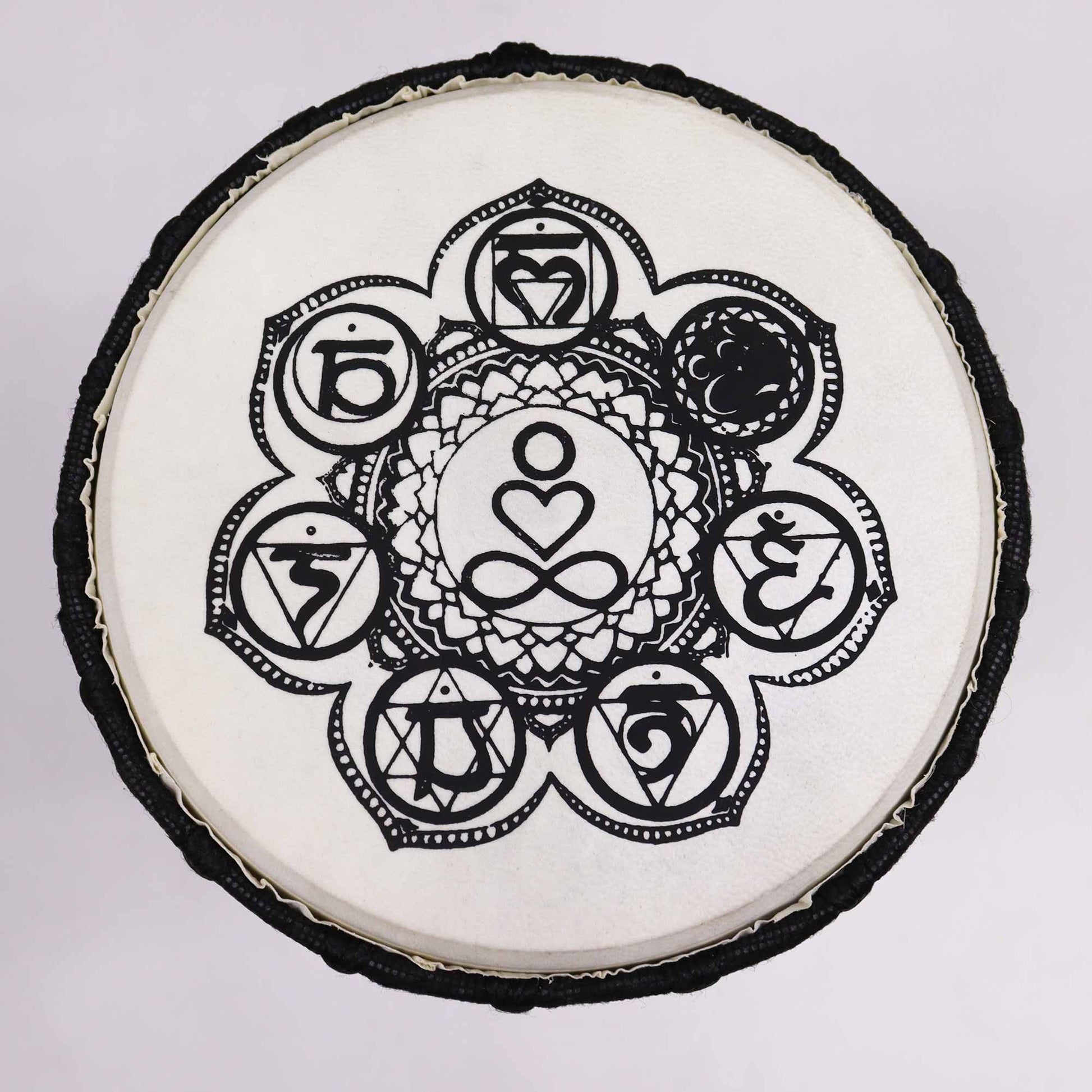 Handcrafted wooden djembe drum with a wide top and intricate chakra symbols on the drum skin.