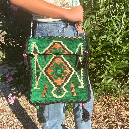 Handcrafted emerald green messenger bag with intricate traditional Turkish Kilim woven patterns and a long strap.