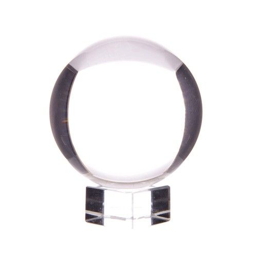 Clear optical glass crystal ball resting on a simple elegant stand against a neutral background.