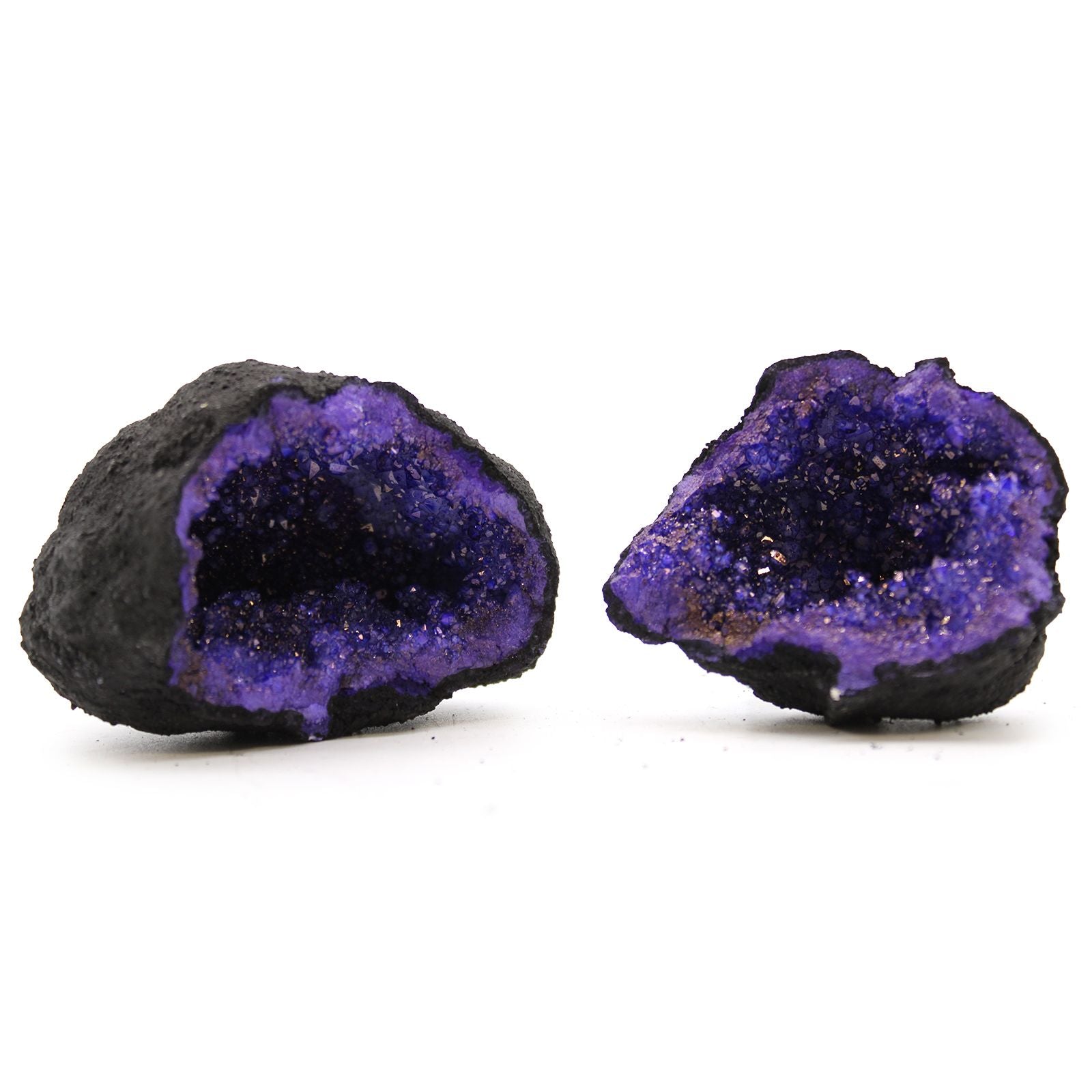 A split open black rock geode revealing vibrant turquoise and purple dyed calcite crystals inside.