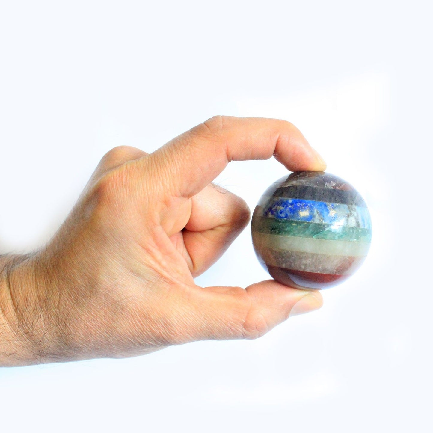 Handcrafted crystal sphere made of seven bonded colourful gemstone layers representing the different chakras.