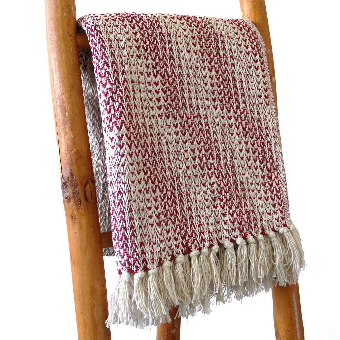 Ruby red and cream two-tone woven cotton throw with decorative tassel fringe.