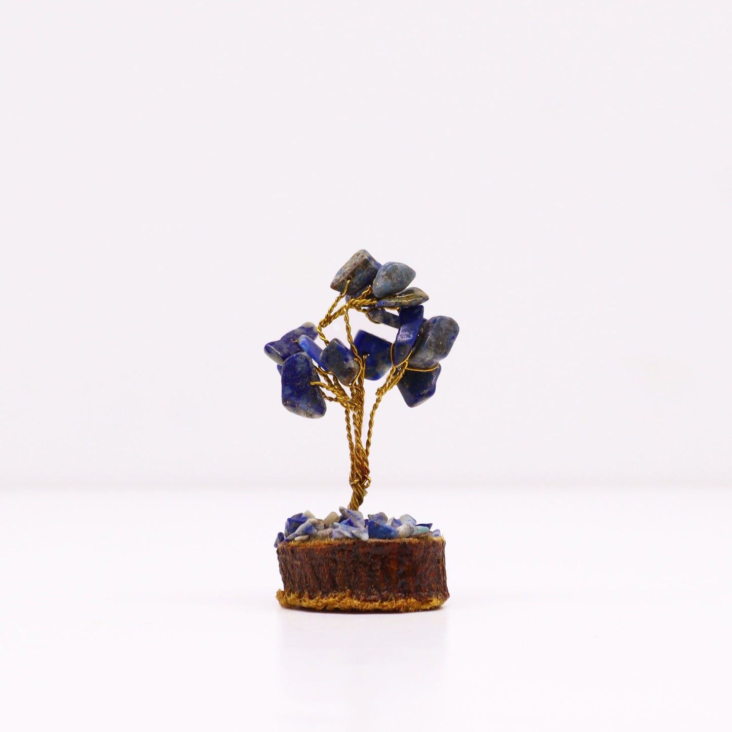 Miniature gemstone tree featuring blue sodalite stones on twisted wire branches set upon a natural wood base.