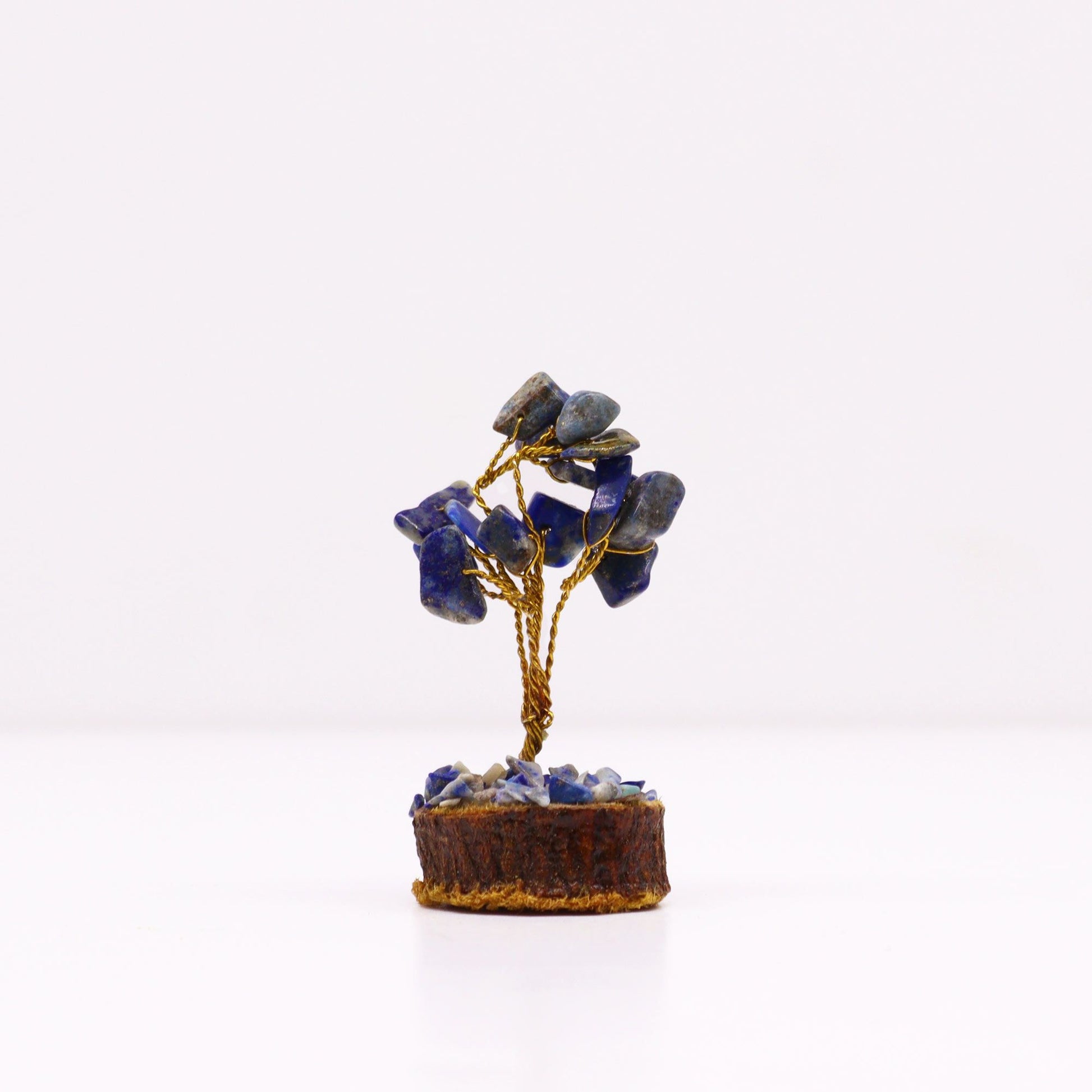 Miniature gemstone tree featuring blue sodalite stones on twisted wire branches set upon a natural wood base.