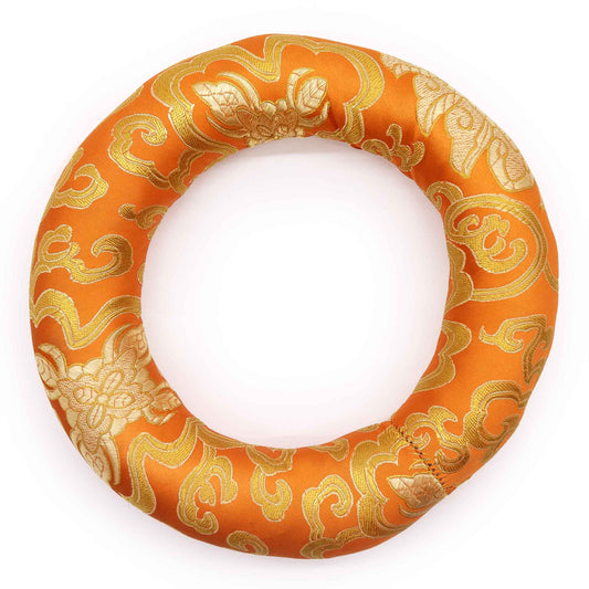 Circular fabric hoop cushion for supporting meditation singing bowls, featuring colourful patterns and embroidery.