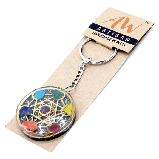 Circular orgonite keyring featuring seven layered chakra stones and copper shavings set in clear resin.