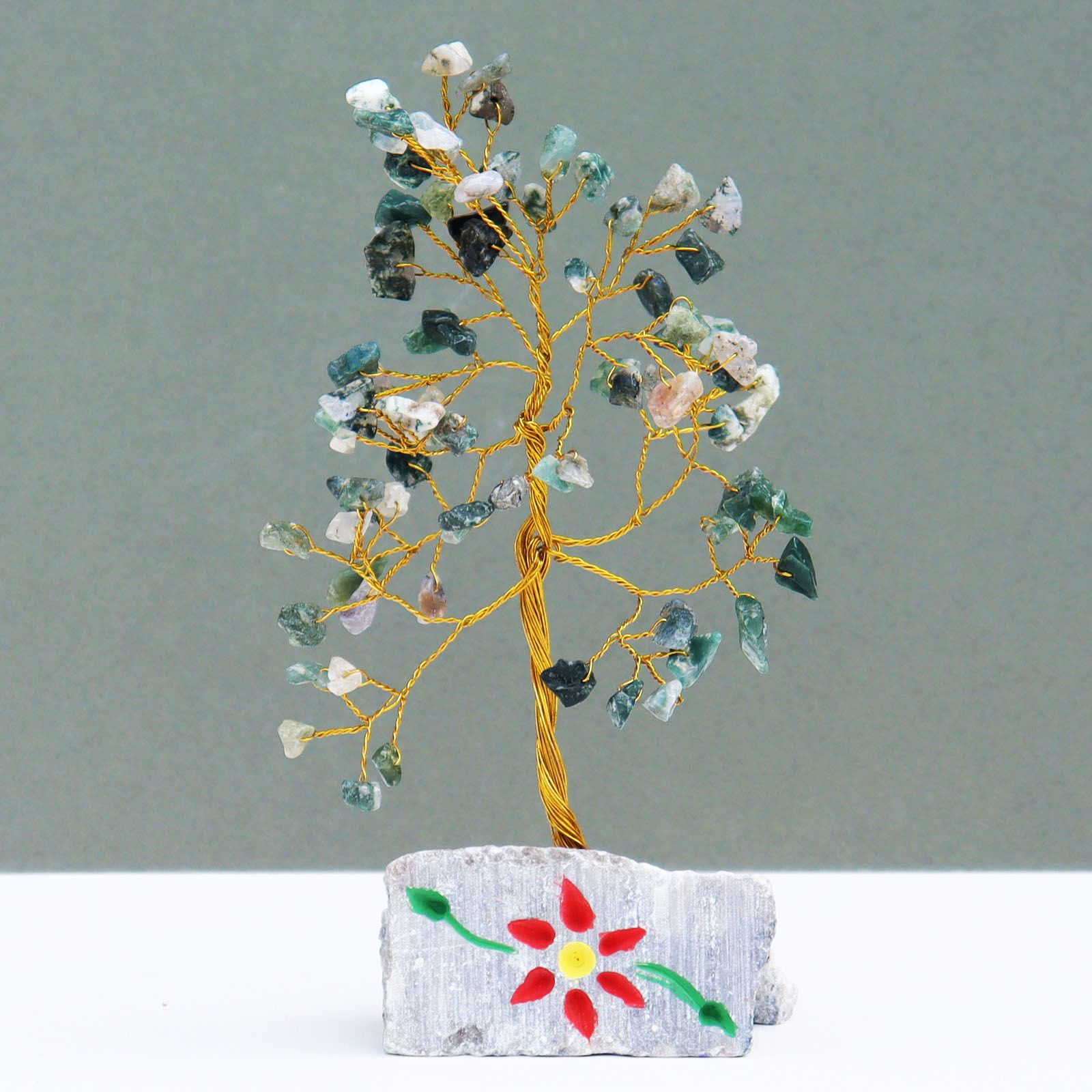 Handmade gemstone tree featuring green moss agate leaves on twisted wire branches set on a natural stone rock base.