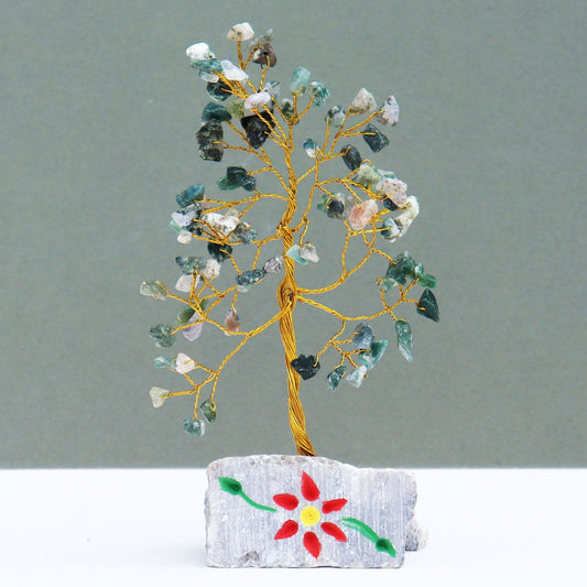 Handmade gemstone tree featuring green moss agate leaves on twisted wire branches set on a natural stone rock base.