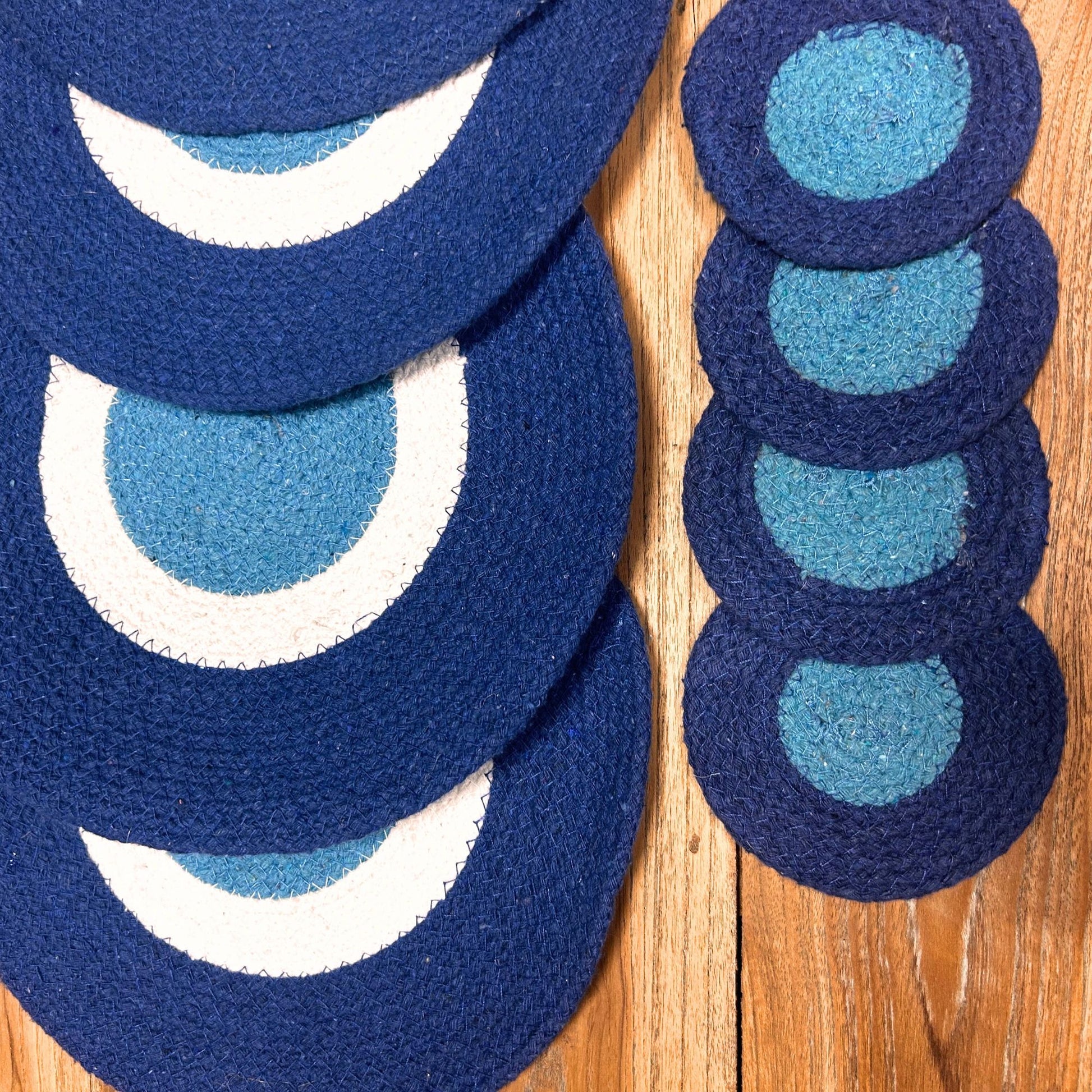Rustic round jute placemats and coasters featuring a blue and white concentric Evil Eye design.
