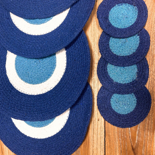 Rustic round jute placemats and coasters featuring a blue and white concentric Evil Eye design.