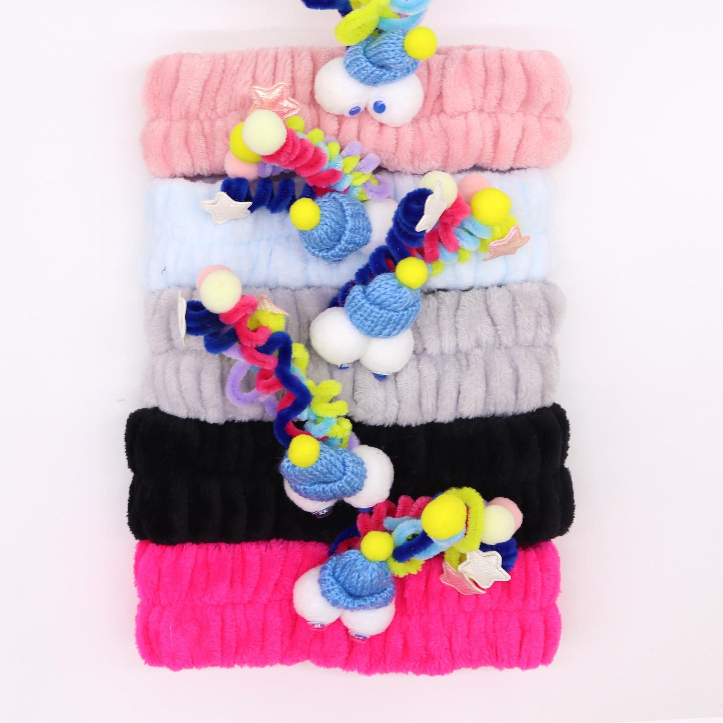 Set of five vibrant, colourful plush headbands featuring quirky monster designs with soft flannel texture.