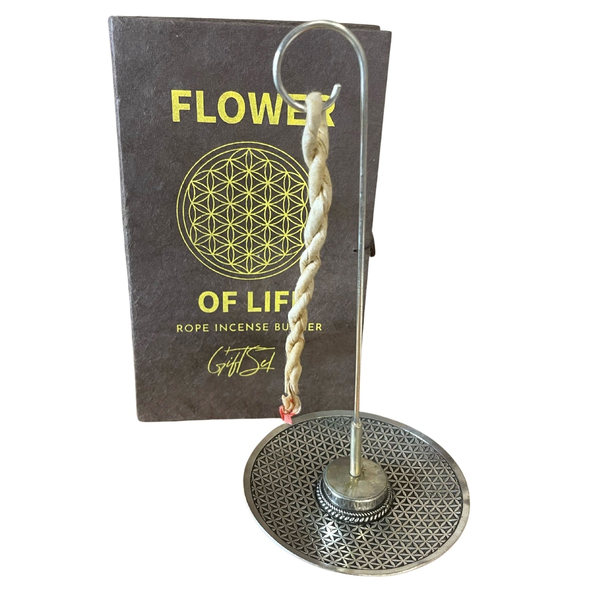 Hand-rolled rope incense bundles alongside a round silver-plated holder engraved with a sacred geometry Flower of Life symbol