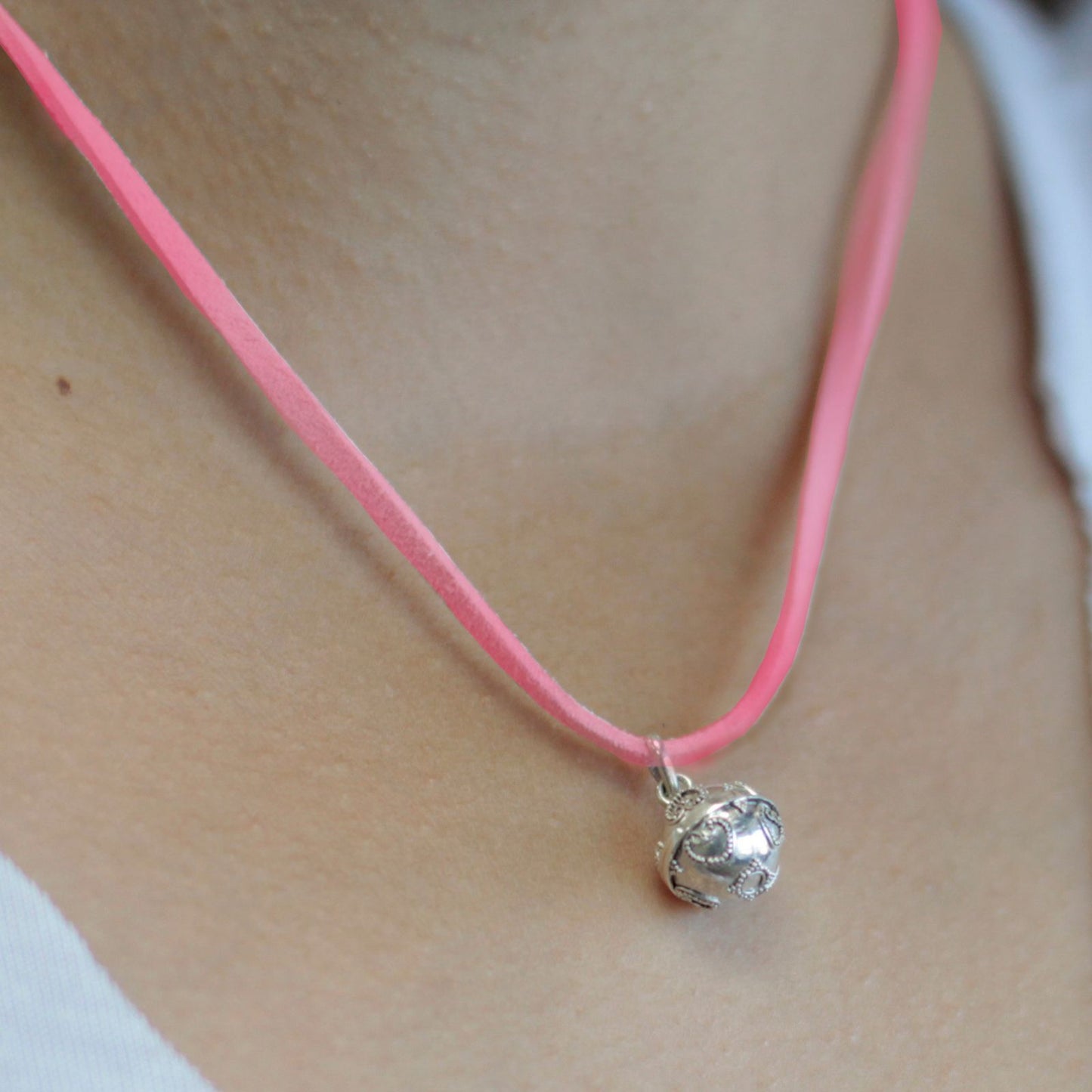 Small 12mm sterling silver angel bell pendant with a delicate ornate design and a small hanging loop.