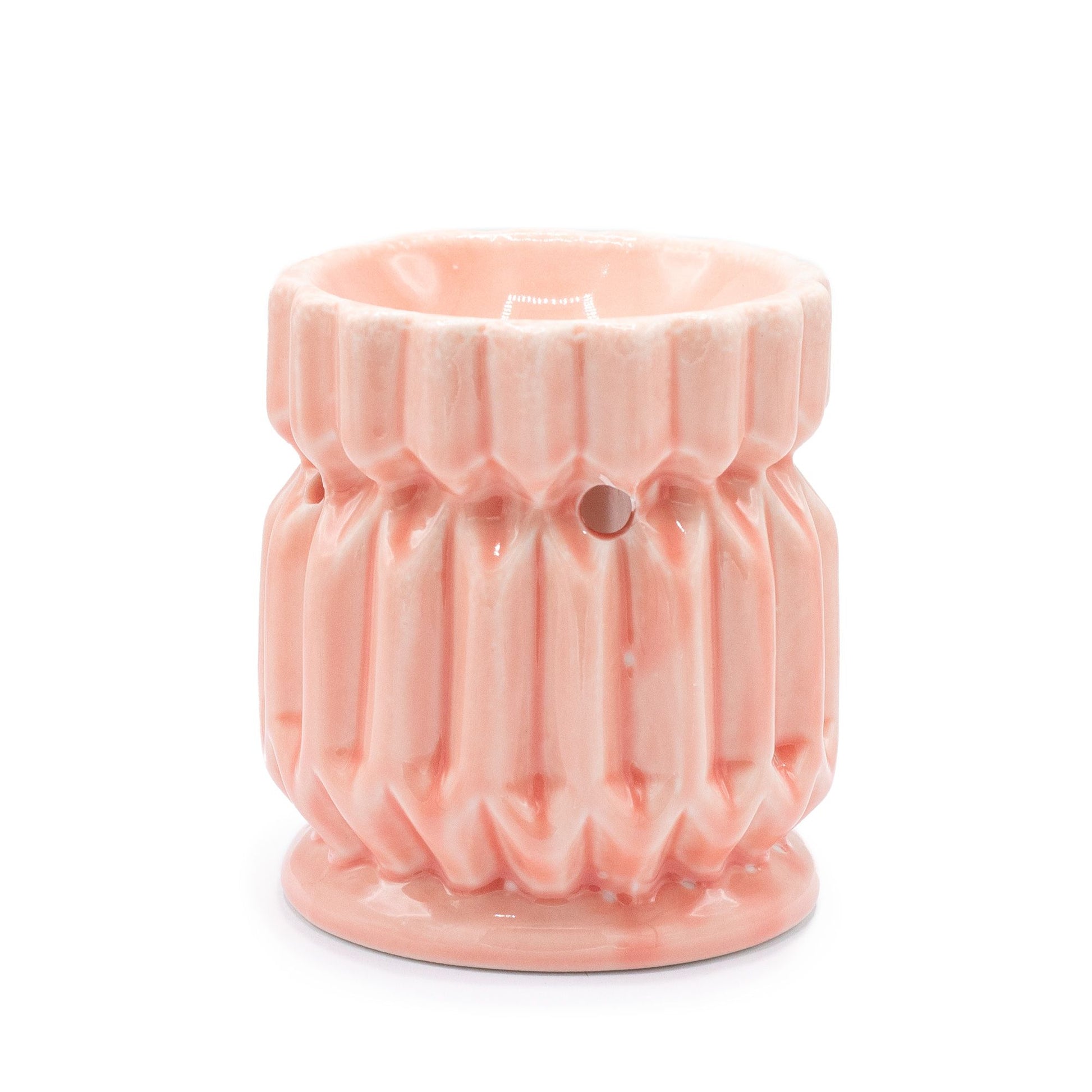 Soft pink ceramic oil burner featuring a modern geometric cut-out design and a deep bowl for wax or oils.