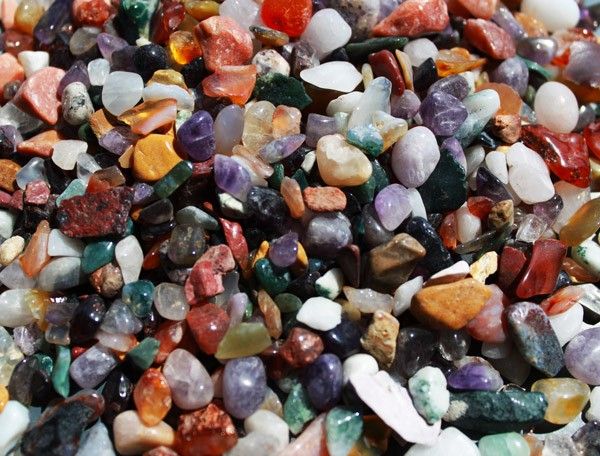 Large collection of small, colourful polished natural gemstone chips in various shapes and sizes.