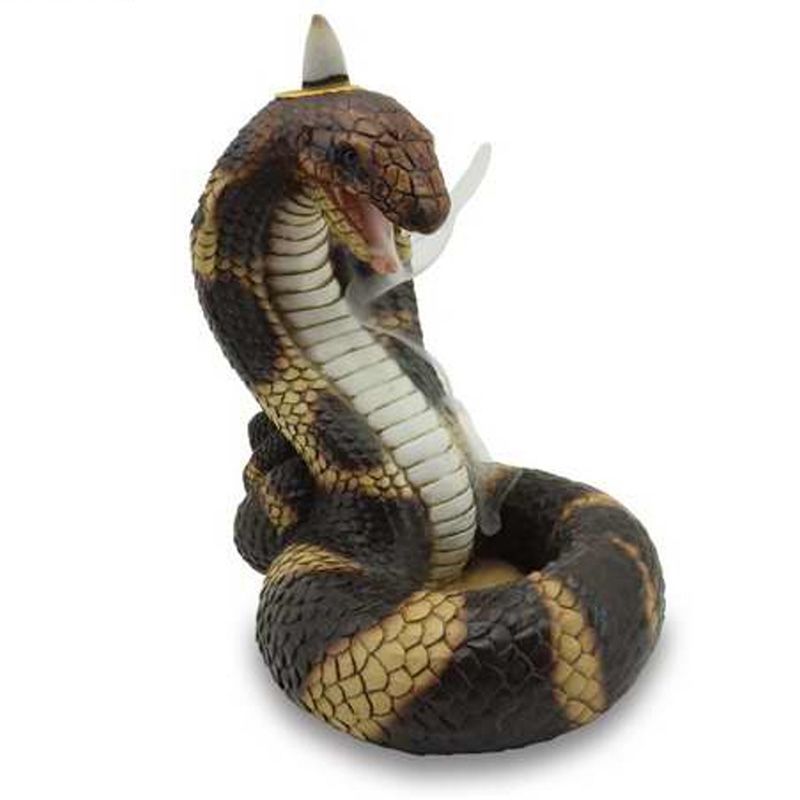 Detailed resin backflow incense burner shaped like a coiled cobra with smoke cascading from its mouth into the coils.