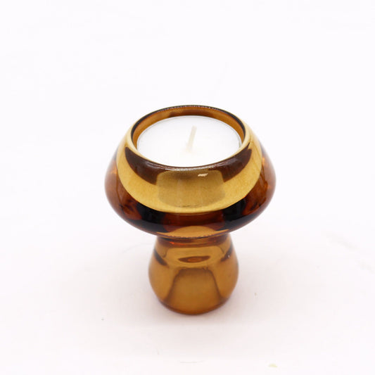 Vintage style antique amber glass mushroom-shaped holder displaying a tall dinner candle on one side.