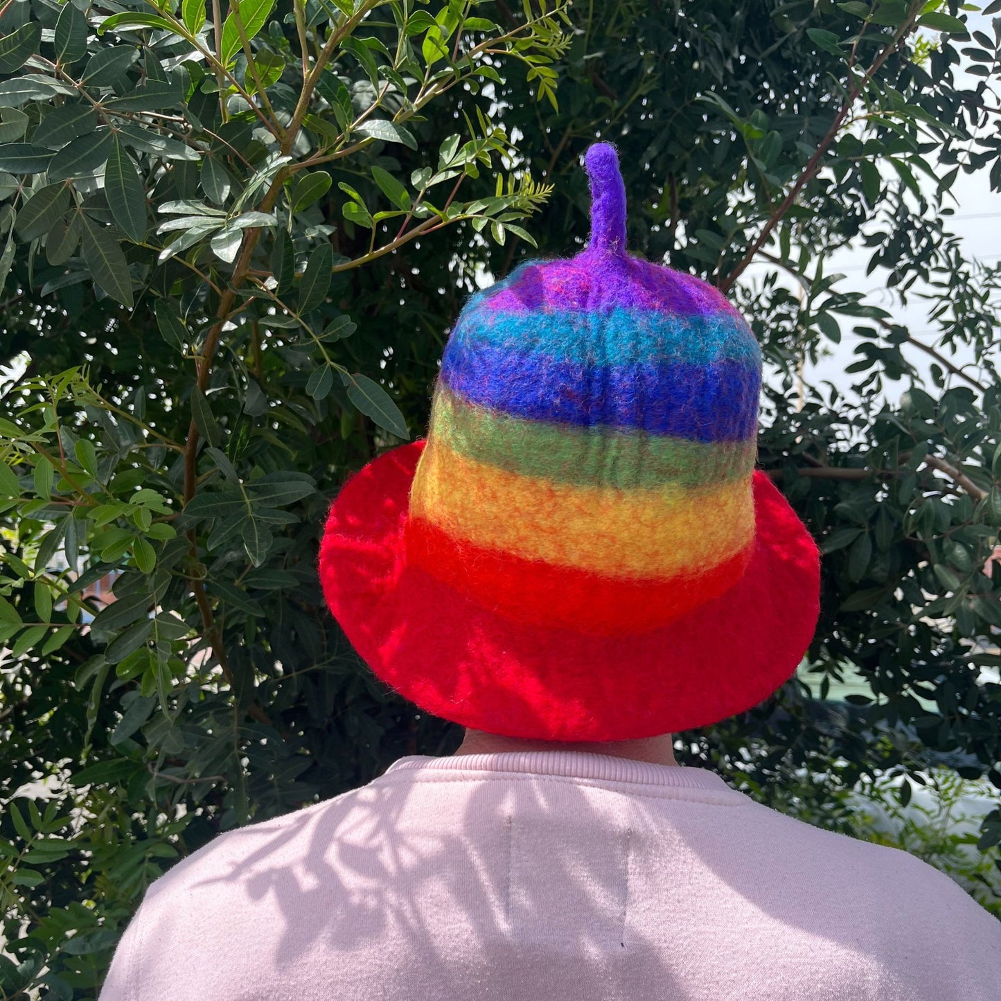 Vibrant rainbow-coloured felted wool sauna hat in a traditional bowl shape.