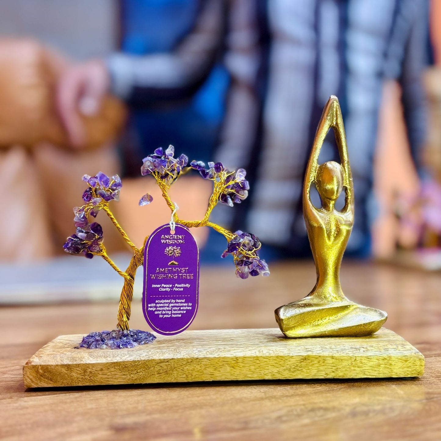 Handcrafted Amethyst gemstone tree with 100 purple chipstones on golden branches in a seated yoga sukhasana pose.
