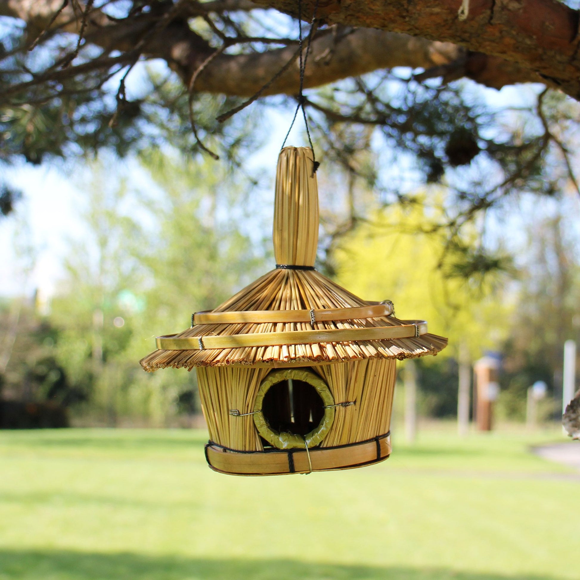 Small round handwoven seagrass bird house with a natural rustic texture and a circular entrance hole.