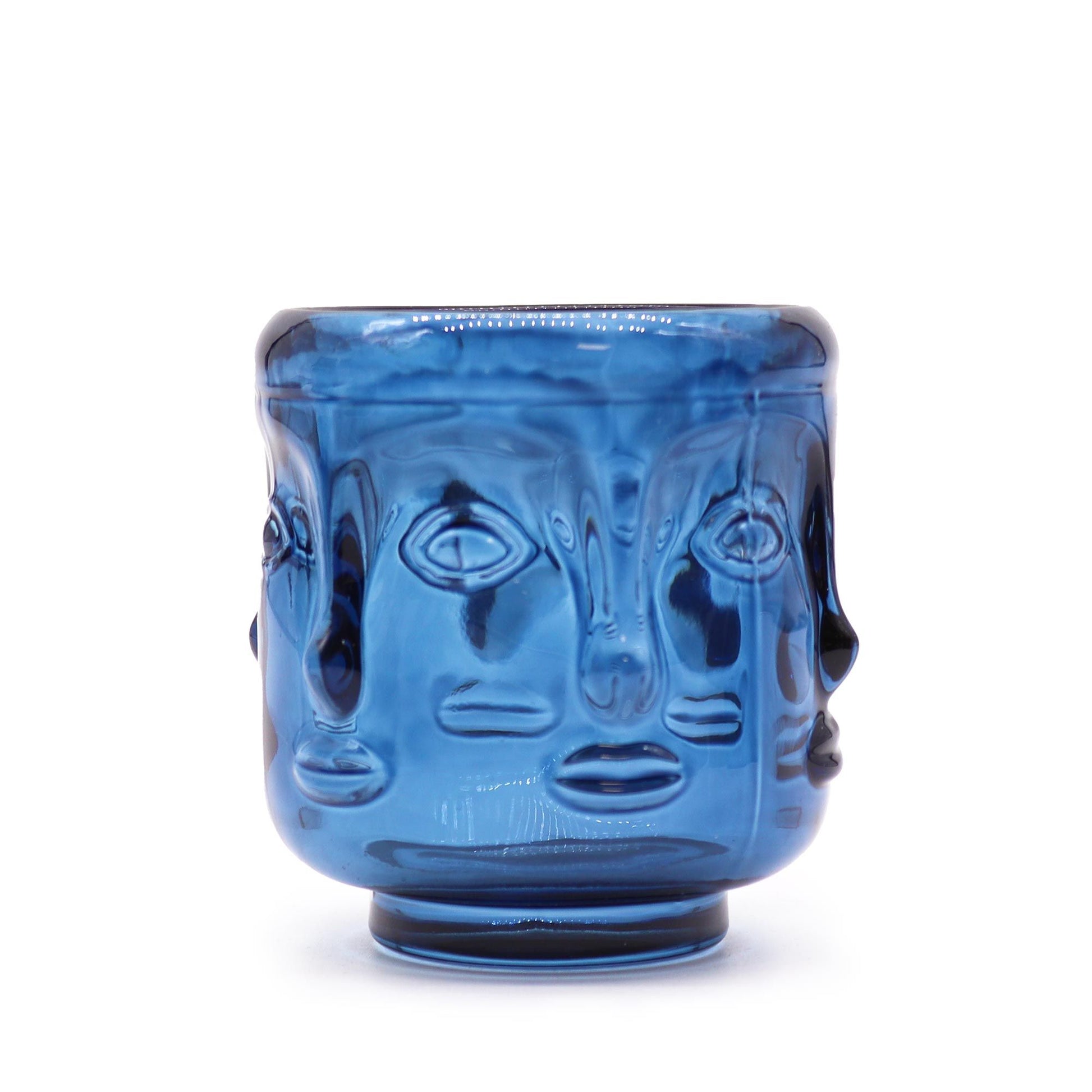 Royal blue glass candle jar featuring embossed Buddha faces in a circular pattern around the exterior.