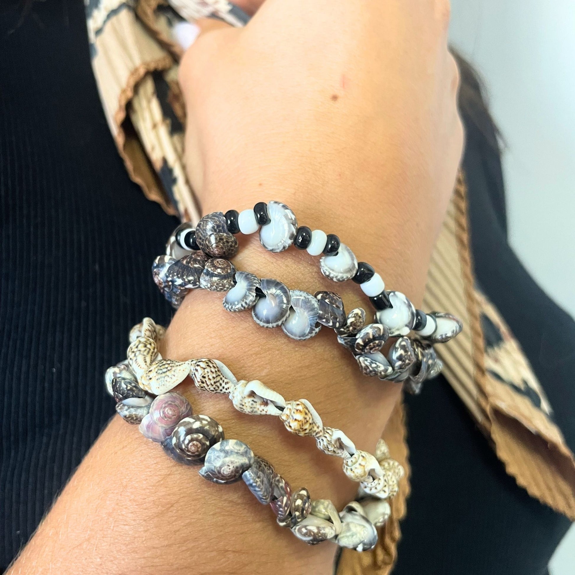 Colourful handmade friendship bracelets featuring small delicate sea shells on adjustable woven cords.