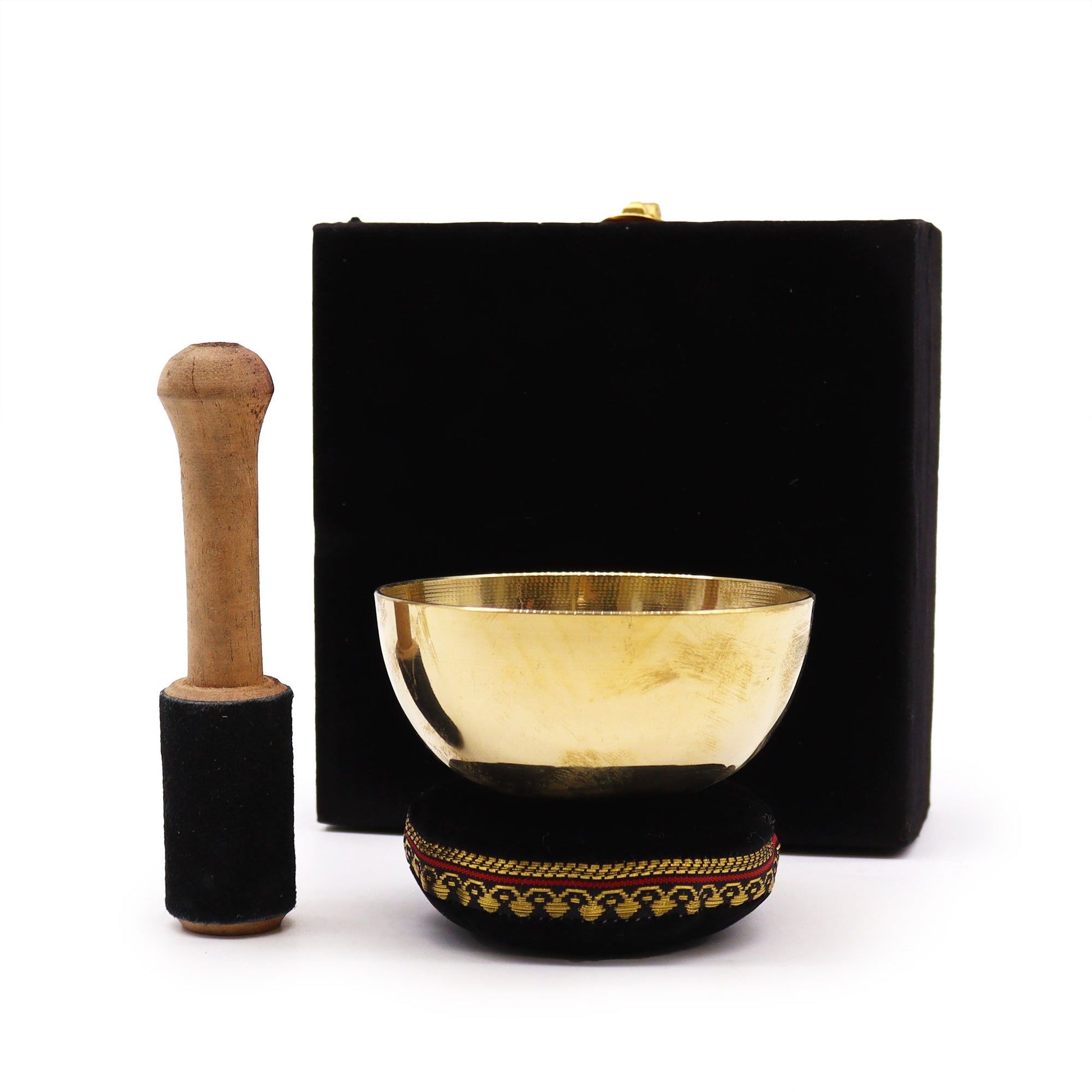 Small brass Tibetan singing bowl set with a red cushion and wooden striker in a decorative padded gift box.