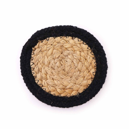 Four round natural jute and cotton coasters with a decorative black stitched border set on a table.