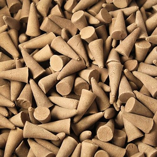 Large collection of aromatic amber-coloured incense cones displaying a smooth texture and uniform 25mm size.
