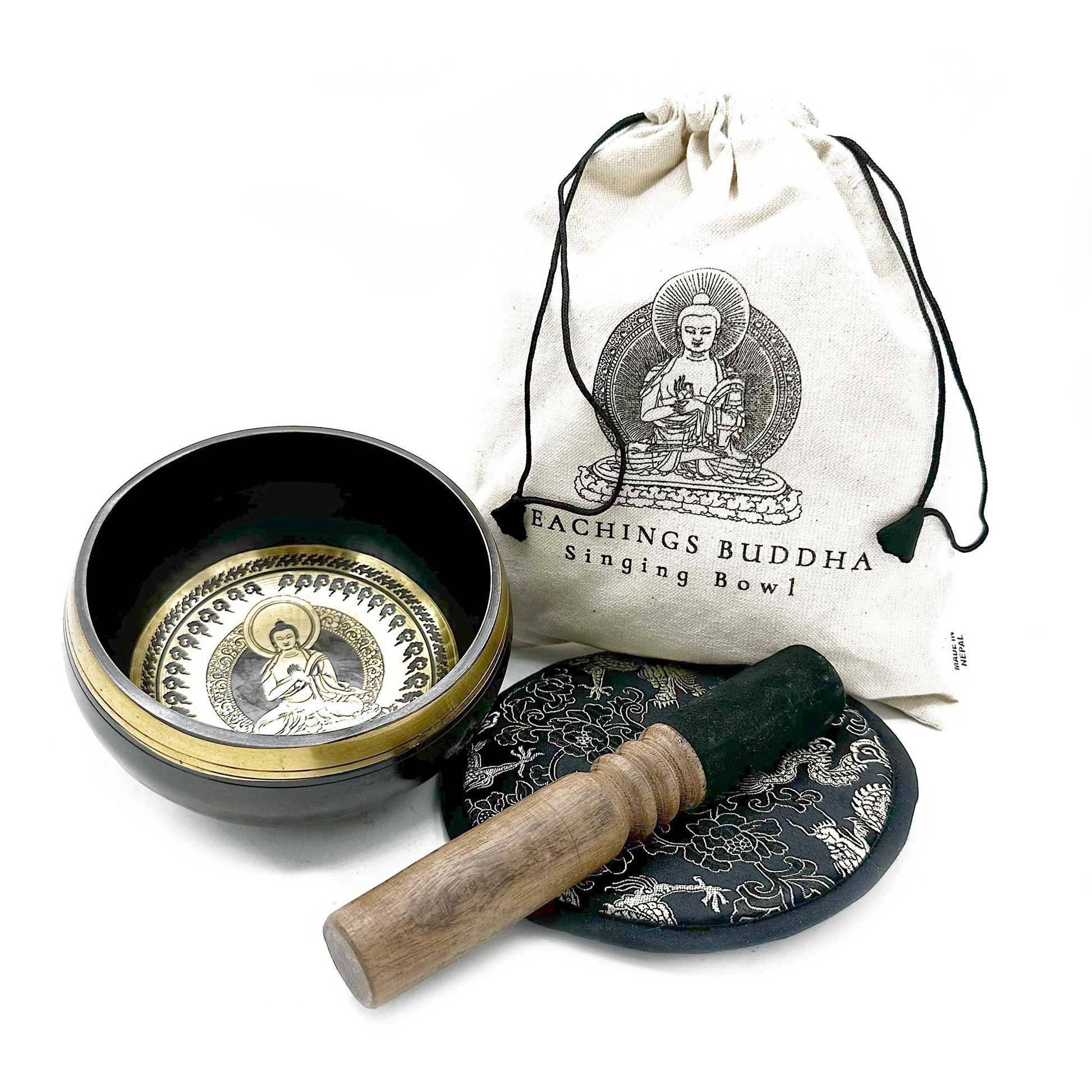 Handcrafted 14cm bronze singing bowl with intricate Buddha teaching engravings, wooden mallet, and patterned cushion.