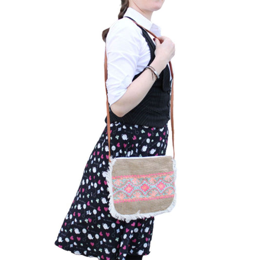 Soft washed jute tote bag featuring colourful summer embroidery, a cotton fringe trim, and a long leather-effect shoulder str
