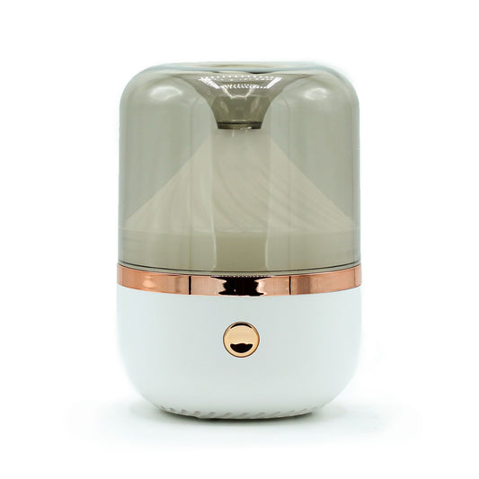 Minimalist white and bronze cylindrical aroma diffuser with soft ambient lighting.