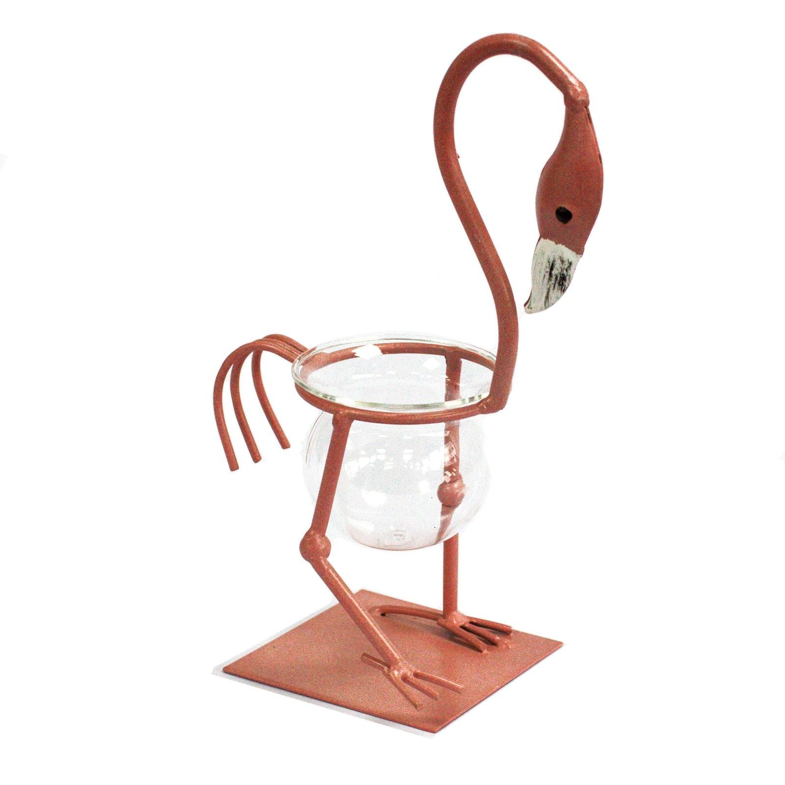 Pink metal flamingo frame holding a clear glass hydroponic laboratory vase for plant propagation.