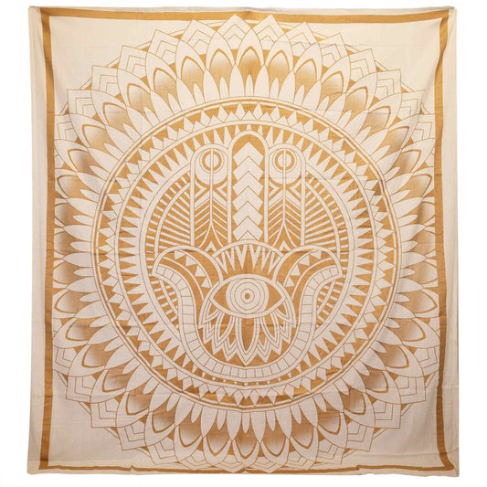 Large cotton bedspread featuring a detailed gold Hamsa hand design on a white background, hung as a wall tapestry.