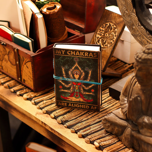 Handcrafted brown leather notebook featuring a colourful printed chakra goddess design and bold spiritual text.