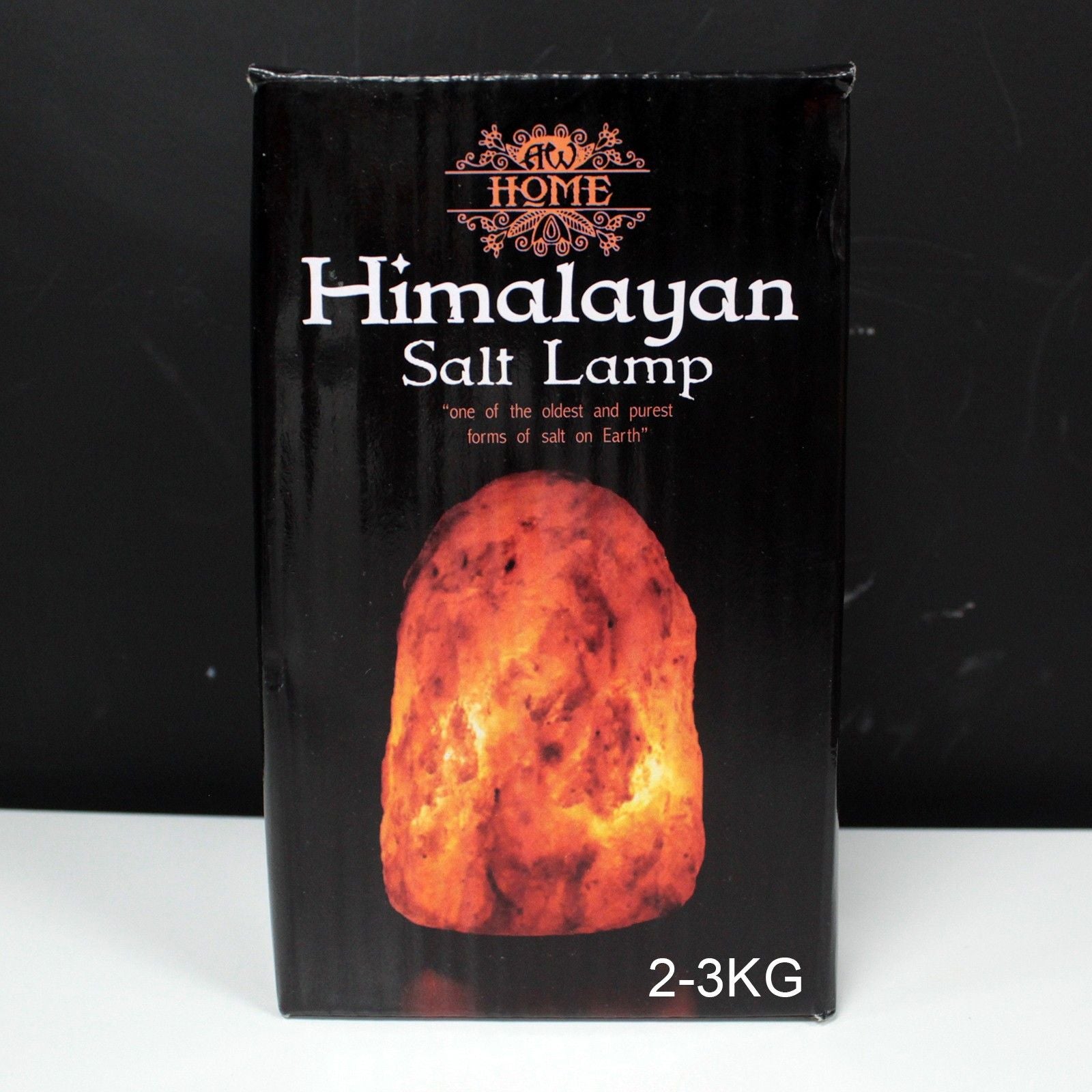 Hand-carved natural pink Himalayan salt lamp on a wooden base emitting a warm orange glow.