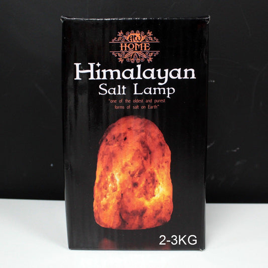 Hand-carved natural pink Himalayan salt lamp on a wooden base emitting a warm orange glow.